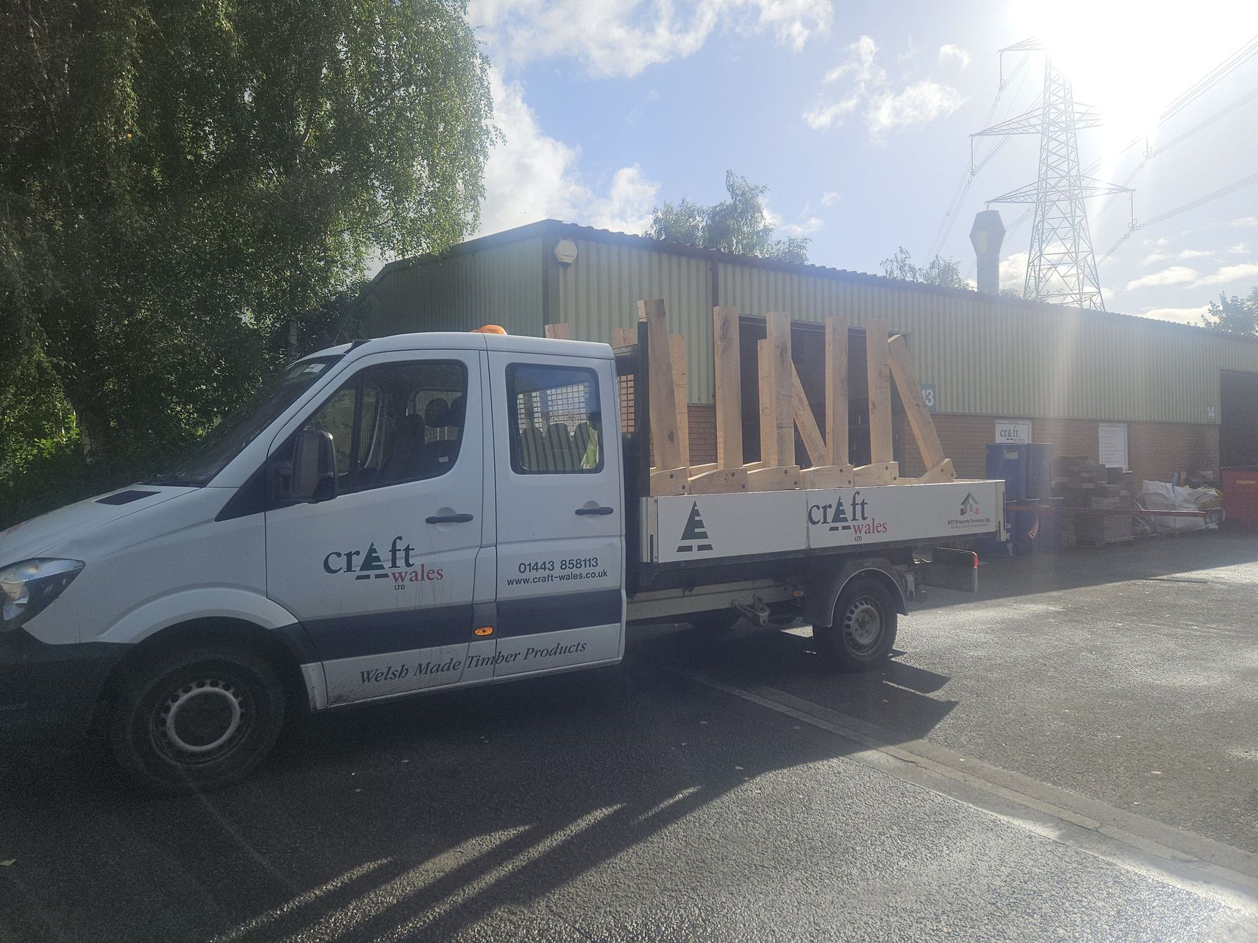 Flatbed van loaded with timber outside the workshop