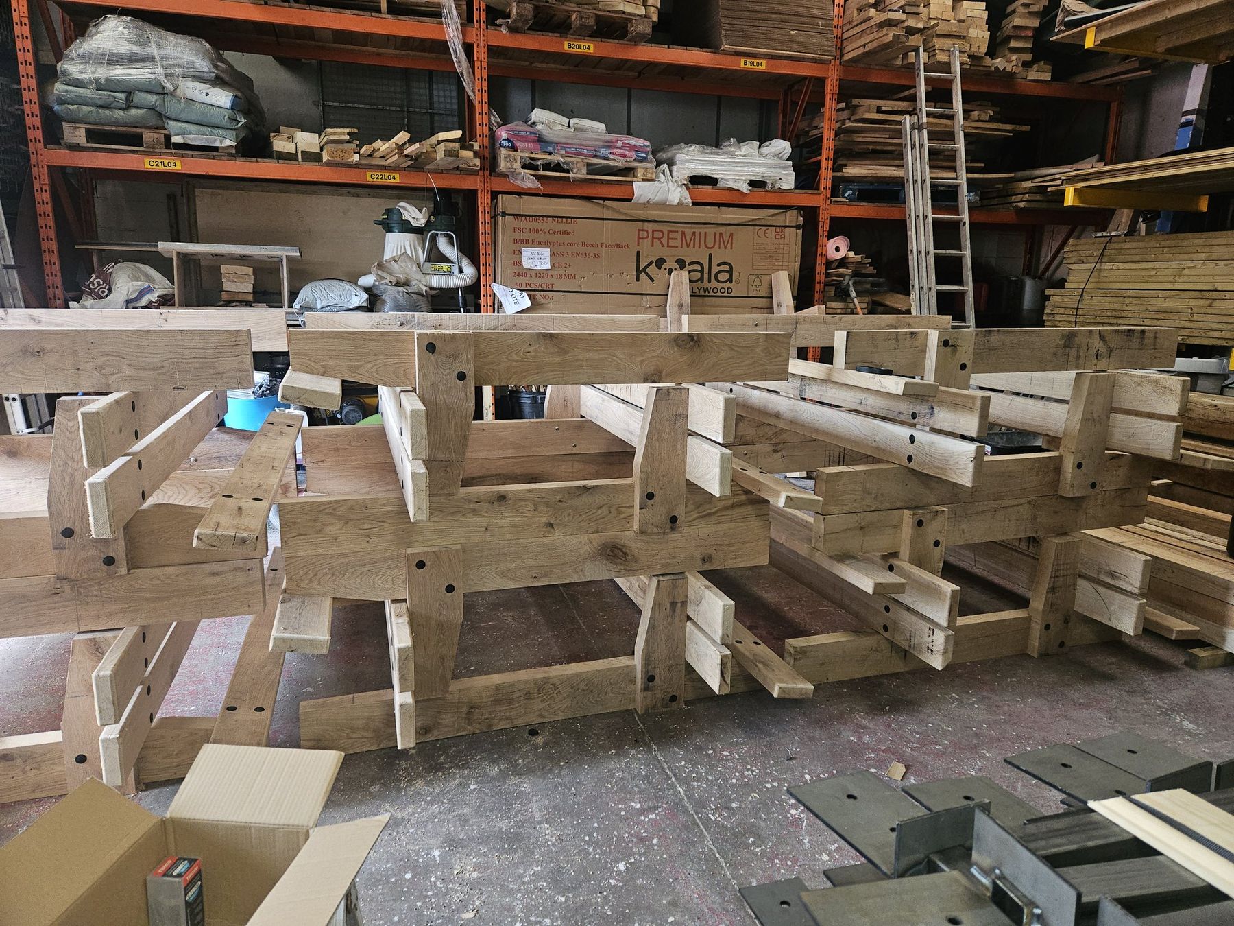 Finished timber benches stacked on racks inside the workshop