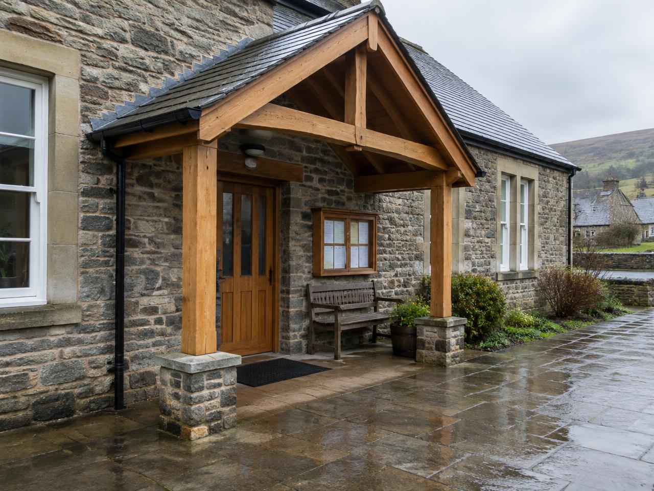 Illustrative timber entrance canopy on a stone Welsh village hall